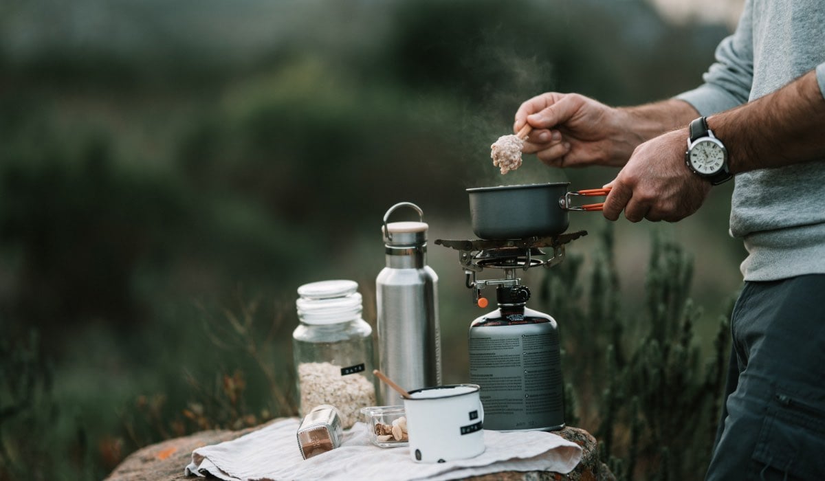 Man Cooking Oatmeal In Nature 